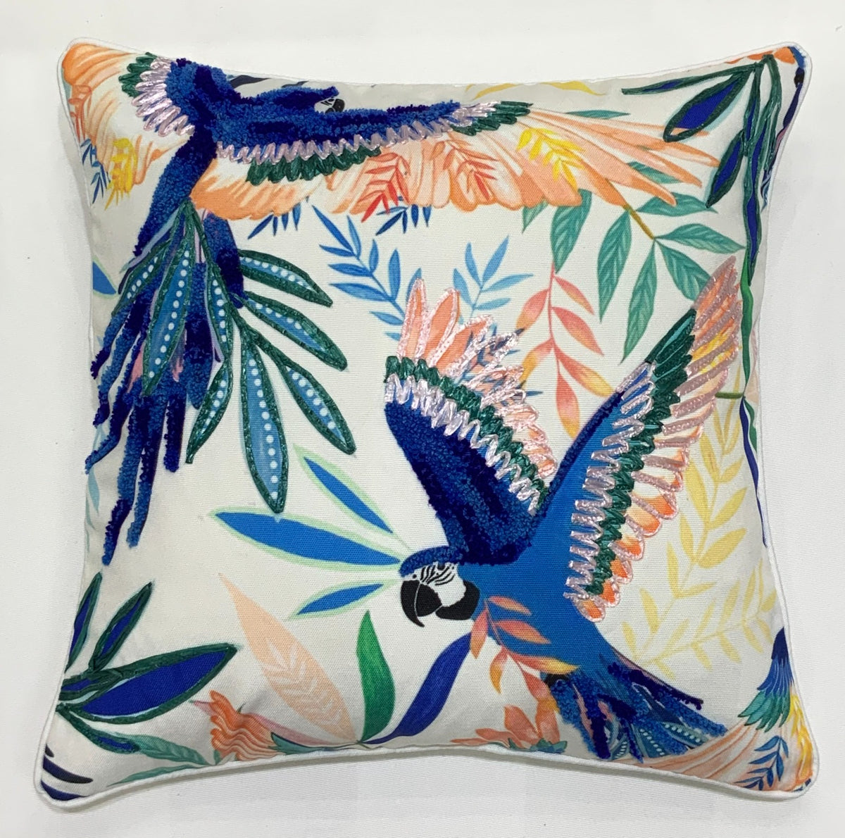 Two blue parrots in flight embroidered on a tropical leaf throw pillow