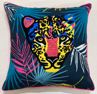 Bright leopard face among palm fronds on a throw pillow with hot pink piping