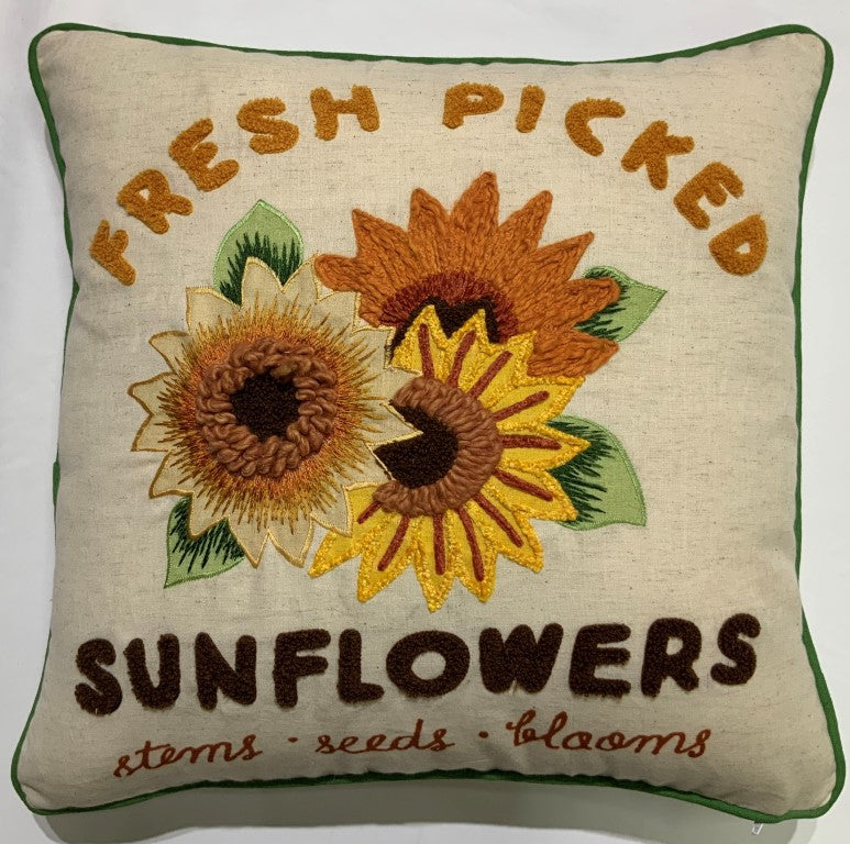 Embroidered sunflowers with retro lettering and green piping on a throw pillow