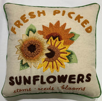 Embroidered sunflowers with retro lettering and green piping on a throw pillow